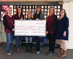 6 women holding a giant check