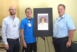 3 people standing by a portrait