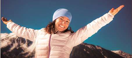 woman with arms outstretched in the mountains