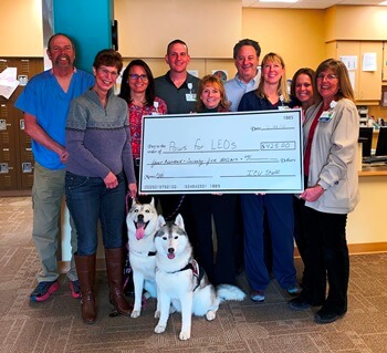 9 people, a large check, and a dog